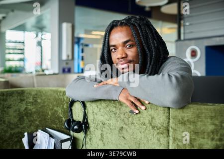 Portrait of Black Man Relaxing in Modern Office Breakout Area Stock Photo