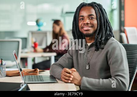 Portrait of Black Man Working at Laptop in Modern Office Stock Photo