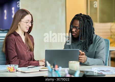 Adult Business Colleagues Collaborating on Laptop in Office Stock Photo