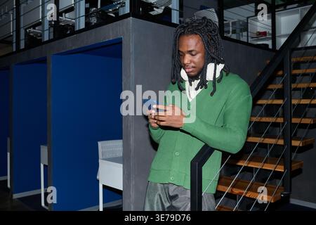 Black Man Checking Smartphone during Break in Modern Office Stock Photo
