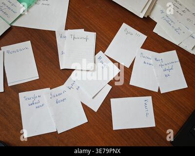 Kirov, Russia - March 12, 2026: Various notes are spread across a wooden desk with reminders and tasks written on them. This shows a personal planning Stock Photo