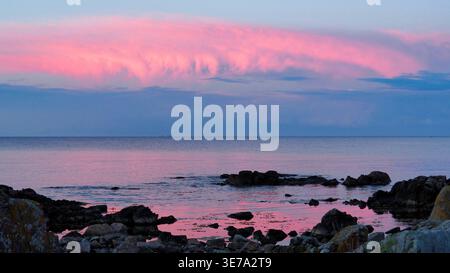 Pink sunset over the Baltic Sea at Melsted, Gudhjem, Bornholm Island, Denmark. Stock Photo
