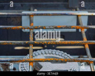 Orange rust and corrosion covering the metal bars of a well-used outdoor camping stove Stock Photo