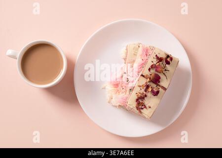 Top view of creative dessert with cotton candy and dried roses served with coffee on pastel background, minimal composition for cafe branding and life Stock Photo