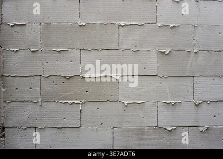 The walls are made of light grey bricks, with the remaining adhesive cement mortar appearing to have overflowed and dried between the joints Stock Photo