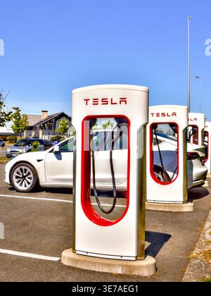 Line of Tesla Supercharger EV charging stations in the car parking area of the Lidl supermarket - Chatellerault, Vienne (86), France. Stock Photo