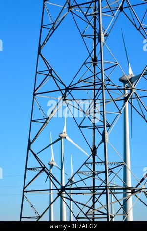 Older high-voltage electricity pylon with background of modern wind turbines - Chatellerault, Vienne (86), France. Stock Photo