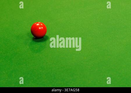 Red billiard ball on green baize, England, UK Stock Photo