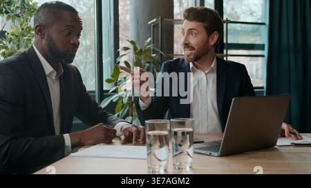 Two business men team in office multiethnic African American businessman sharing good idea Caucasian boss ecxited agree communicating diversity Stock Photo