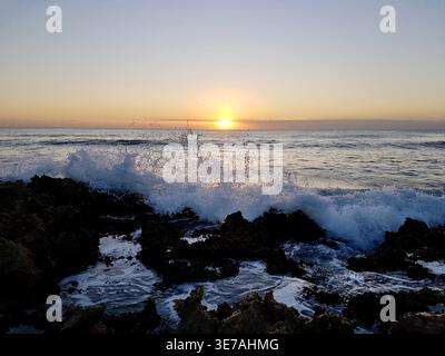 Peaceful Sunrise over the Caribbean Sea with Splashing Waves on Rocky Coastline, Akumal, Mexico Stock Photo