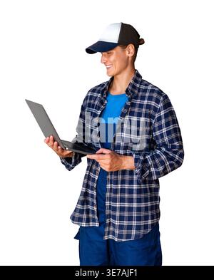 Female worker in blue plaid shirt and cap using laptop and modern digital technology while standing, isolated on white background Stock Photo