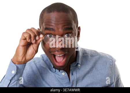 Cheerful Black man with mouth opened touching eyeglasses standing against white background Stock Photo