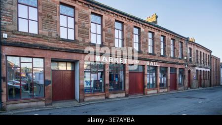 Annan old Market Hall, a historic building with sandstone facade and large windows, stands on a quiet street under a clear blue sky Stock Photo