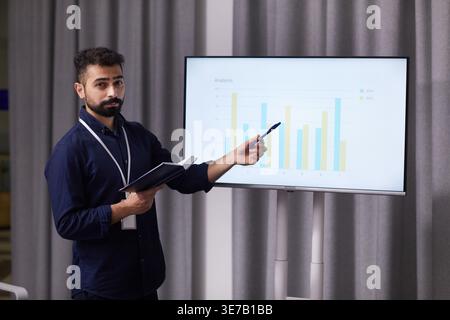Mixed race doctor explaining graph standing in boardroom Stock Photo
