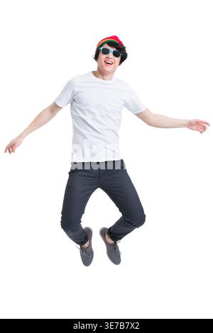 Cheerful Chinese male wearing sunglasses jumping against white background in studio Stock Photo