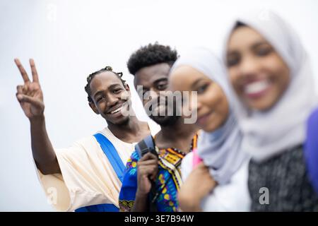 Smiling Black and Muslim college students standing with backpacks against white background in studio Stock Photo