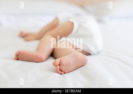 Sleeping Chinese baby boy lying on bed at home Stock Photo