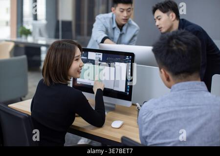 Chinese IT experts working together on computer in office Stock Photo