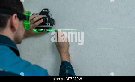 A man measures distance with a laser level.  Stock Photo
