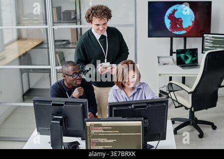 Diverse group of programmers developing security program on computers during their work in office Stock Photo