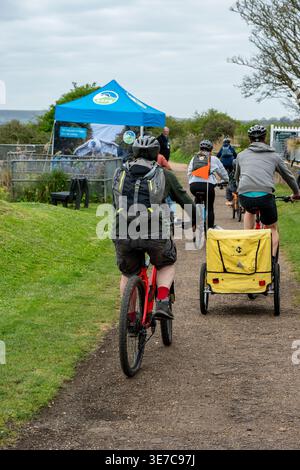 Young families riding bicycles together along a cycle track near Yarmouth on the isle of wight, England, UK Stock Photo