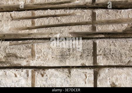 Close up of a rough white shell rock surface in an abandoned quarry. Natural limestone background with deep horizontal cut lines from a stone saw, no Stock Photo