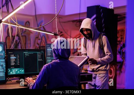 Hackers opening black box with illegal technology for network system hacking. Internet criminals planning phishing attack and examining case with equipment for breaking into server Stock Photo