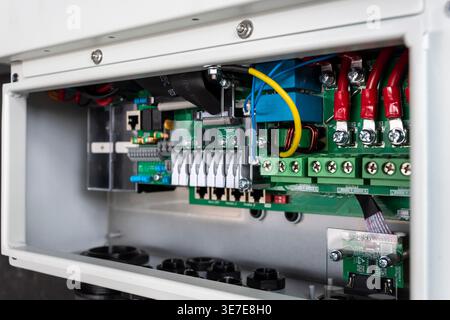 Detailed view of an industrial electrical control panel featuring a printed circuit board (PCB), terminal blocks, relays, and organized wiring. Stock Photo