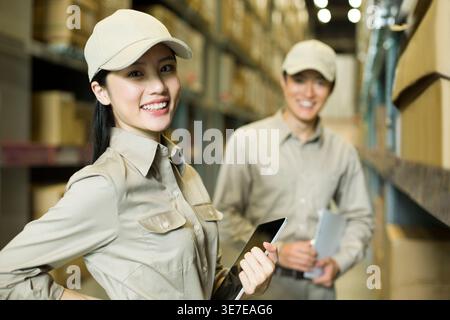 Chinese logistics workers standing in warehouse Stock Photo