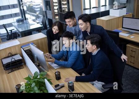 Chinese IT experts working together on computer in office Stock Photo
