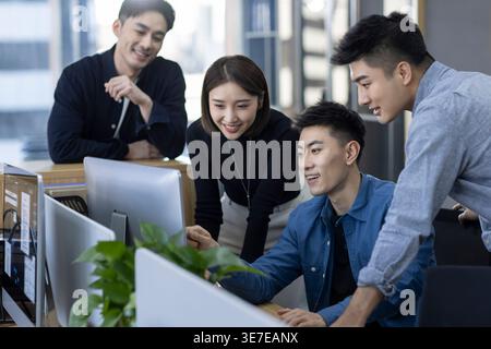Chinese IT experts working together on computer in office Stock Photo