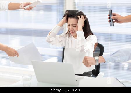 Frustrated business woman scratching head while sitting at table with computer in office Stock Photo