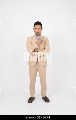 Serious Asian businessman holding eyeglasses leaning elbow on hand standing against white background in studio Stock Photo