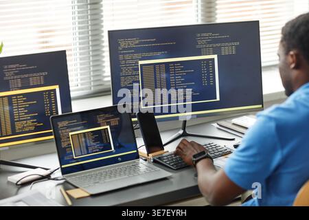 Black male programmer working on computer sitting at  table in office Stock Photo