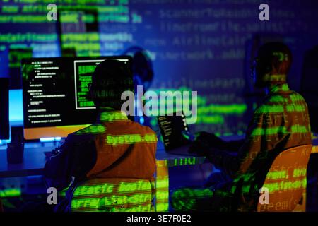 Diverse group of programmers using computers working together sitting at table in offce Stock Photo