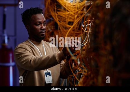 Black male system administrator setting up server network and doing maintenance in server room Stock Photo