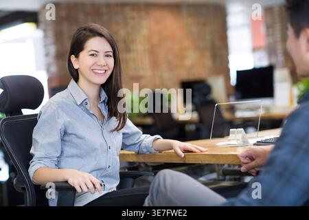 Smiling Chinese business people working together developing smartphone in office Stock Photo
