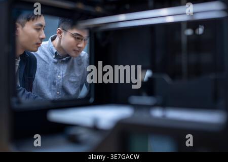 Chinese male IT experts using 3D printer in office Stock Photo