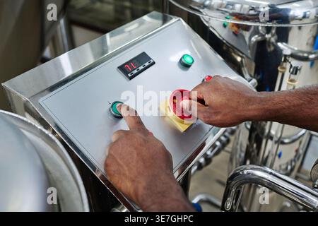 Black man operating machinery standing in factory Stock Photo