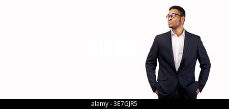 Young Black businessman wearing suit with eyeglasses looking away with hands in pockets standing against white background Stock Photo