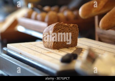 Freshly baked bread sitting on a cutting board Stock Photo