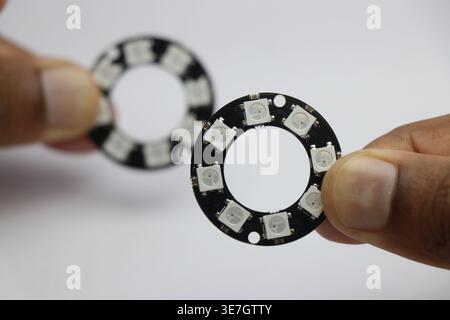 RGB Led ring light with 8 leds held in the hand on white background. Pixel ring light for electronics project Stock Photo