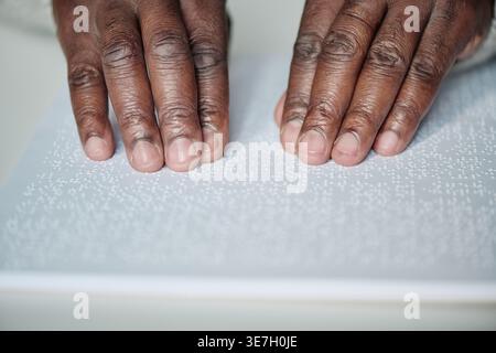 Hands of Black man using braille at the table at home Stock Photo