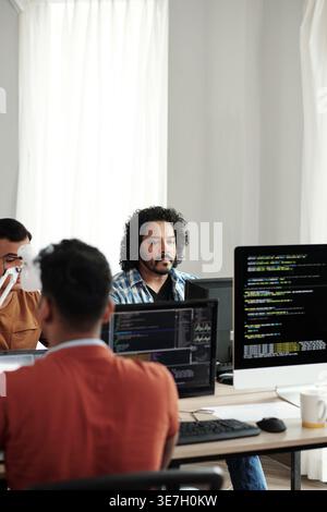 Indian male web developers writing codes for new computer program in IT office Stock Photo