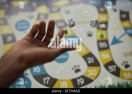 Hands of Black man throwing dices on board game while standing at table in college library Stock Photo