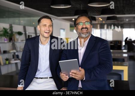 Two smiling businessmen engage in positive communication in coworking Stock Photo