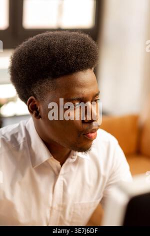 Serious Black businessman sitting at table working in office Stock Photo