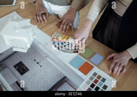 Close-up shot of hands choosing color from palette in office Stock Photo