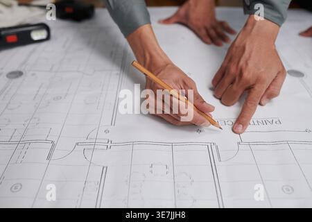 Asian male engineers brainstorming about floor plans and design of the building standing on construction site Stock Photo