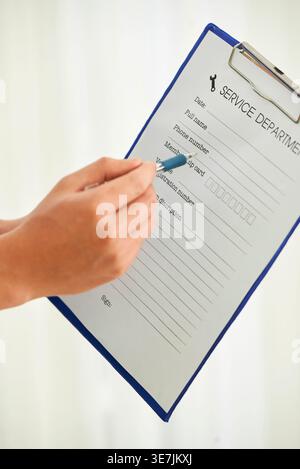 Cropped image of Asian repairman hands pointing on document information Stock Photo